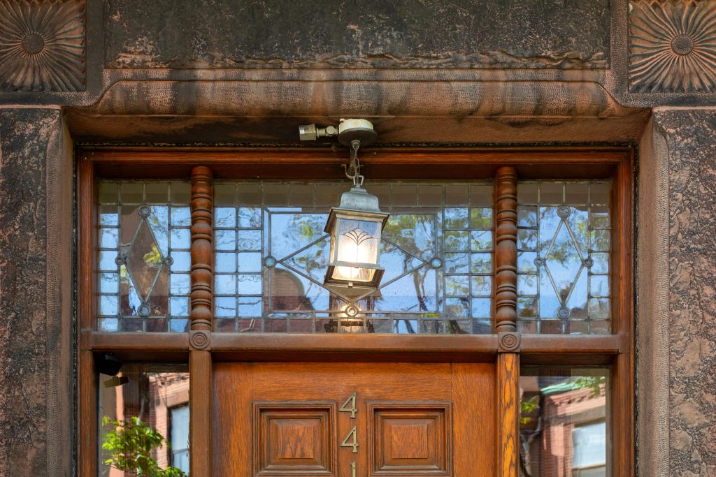 classic doorway with geometric transom window and glowing lantern light
