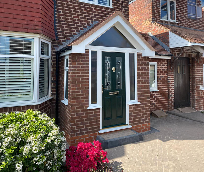 Large porch with Apex roof and black door.