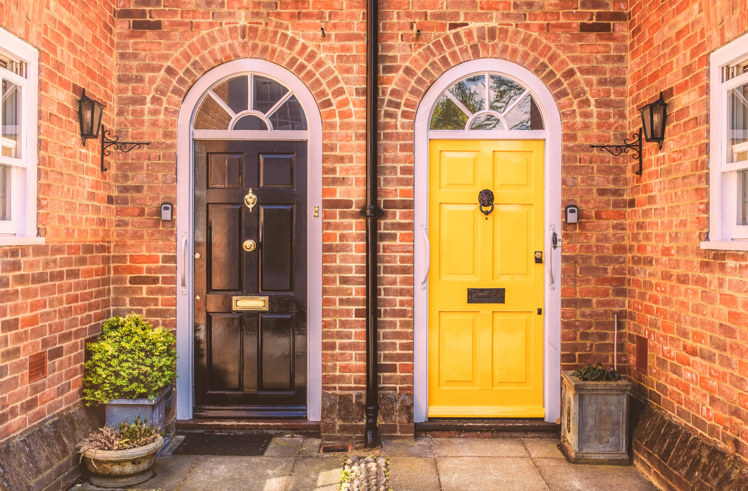 Two residential arch front doors, one yellow, one black